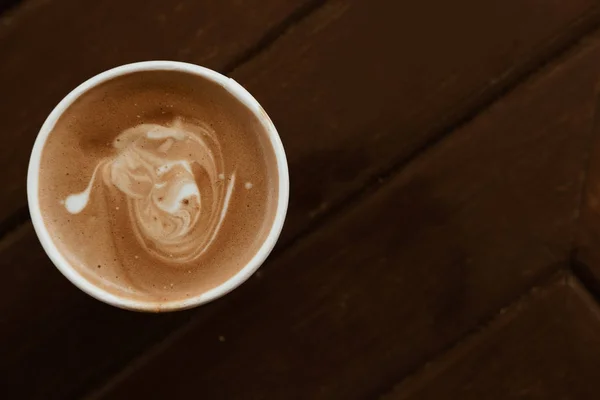 Heißer Cappuccino-Kaffee in weißer Tasse auf Holztisch — Stockfoto