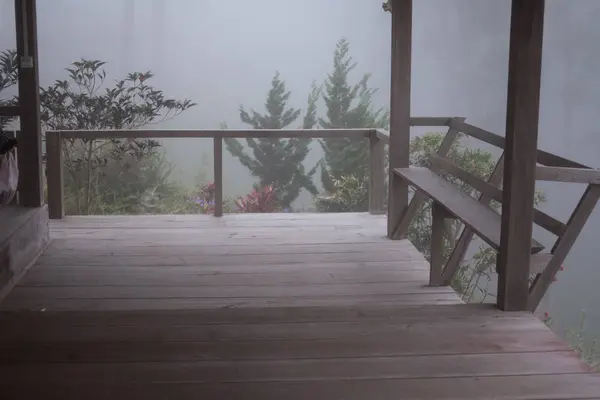 Balcone in legno nebbia e nebbia. terrazza in fredda serata autunnale. chai — Foto Stock