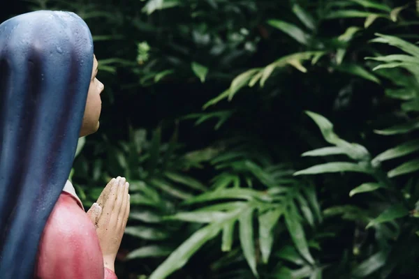 Mulher orando com estátua de mão dobrada. escultura em católico romano — Fotografia de Stock