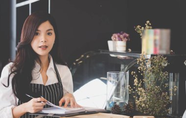 kahve dükkanında kasaya defter ile küçük işletme sahibi. Fe