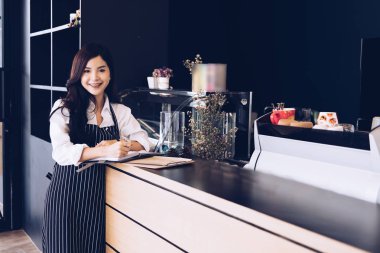 kahve dükkanında kasaya defter ile küçük işletme sahibi. Fe