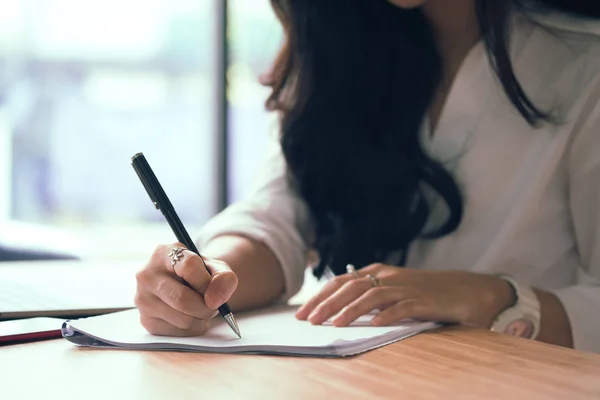 Empresaria escribiendo en papel en el lugar de trabajo. joven mujer entrep — Foto de Stock