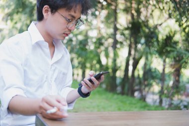 Smartphone ve sigara açık tutan adam. sosyal ağ commu