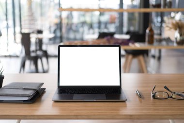 Tükenmez kalem, bilgisayar, gözlük, defter ofis masasında. Bu