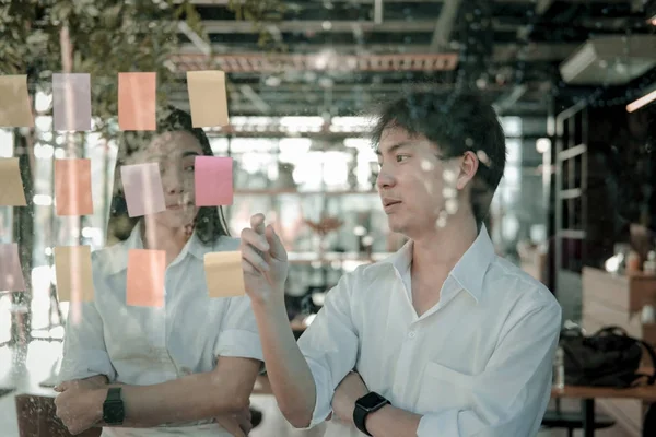 Ο άνθρωπος & γυναίκα συζητούν δημιουργική ιδέα με αυτοκόλλητα νότες για glas — Φωτογραφία Αρχείου