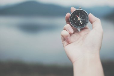 Pusula yönü açık aramak için tutan el. seekin adam