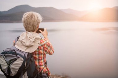 Gezgin uzun yürüyüşe çıkan kimse adam göl kenarında hiking sırt çantası. Turizm backp