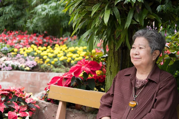 Una anciana descansando en el jardín. anciana mujer relajándose en parque . — Foto de Stock