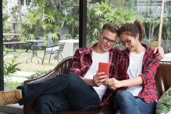 Young couple in love smile & look at smart phone. caucasian man — Stock Photo, Image