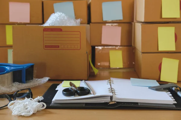 Notebook, packing accessories at workplace of startup small busi — Stock Photo, Image