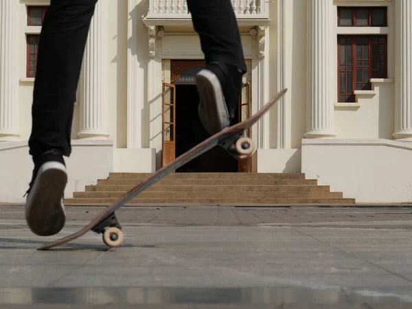 Skateboarder skate & sprong beige fenikshal buitenshuis. m — Stockfoto