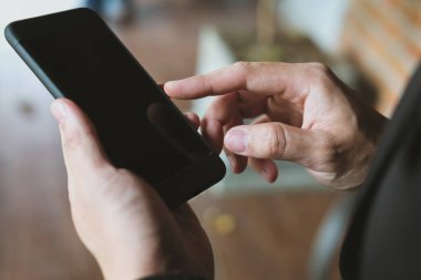 Smartphone holding ve uygulama adam manifatura mesaj kullanarak iş adamı 