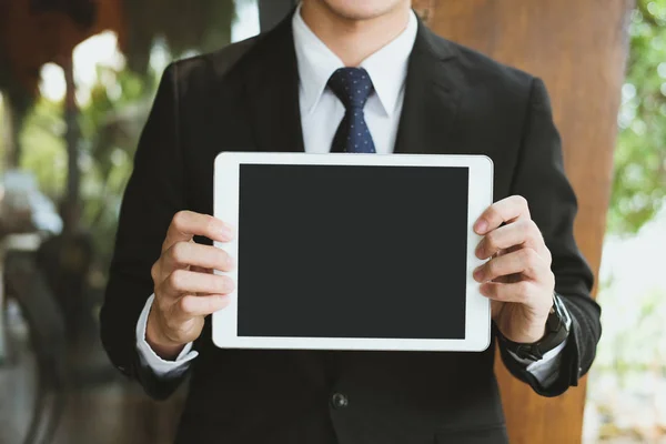 Empresário segurar tablet digital no local de trabalho. jovem mostra em — Fotografia de Stock