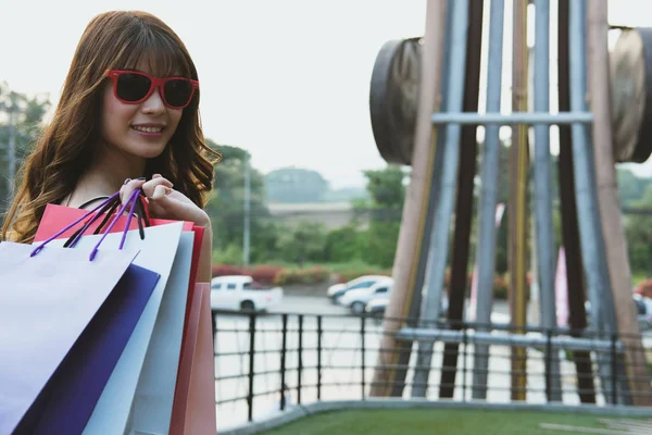 Lycklig kvinna håller färgglad shopping väska utomhus. Shopaholic l — Stockfoto