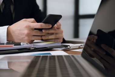 Smartphone holding ve uygulama adam manifatura mesaj kullanarak iş adamı 