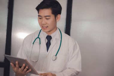 Tablet hastanede tutan genç doktor. Uygulayıcı okuma da