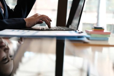 bir kredi kartı tutan ve online shoppi için bilgisayarı kullanan kadın