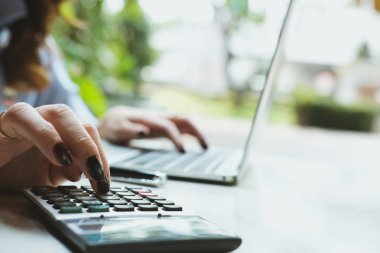dizüstü bilgisayar hesap makinesi ile çalışmaya genç iş kadını 