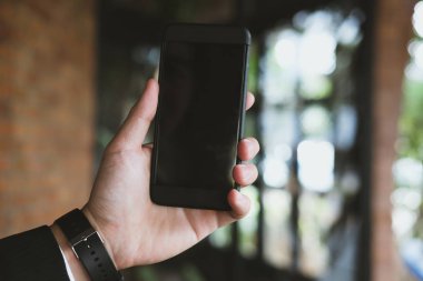 smartphone café restoranında tutan el mockup görüntüsü. mobi