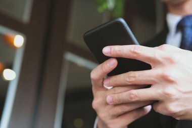 Smartphone holding ve uygulama adam manifatura mesaj kullanarak iş adamı 