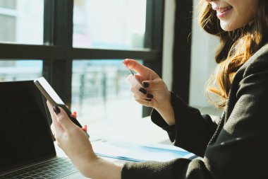 bir kredi kartı tutan ve akıllı telefon için online sho kullanarak kadın