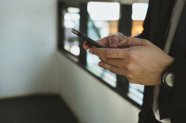 Ofiste akıllı telefon kullanan bir iş adamı. erkek metni