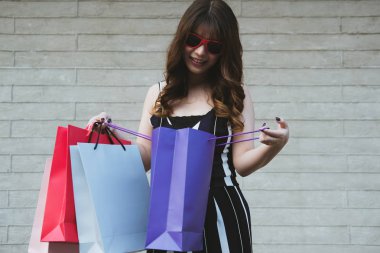 Holding ve renkli alışveriş çantası açık bakarak mutlu kadın