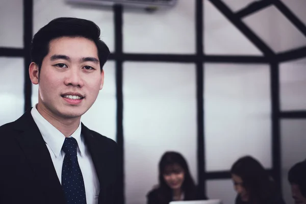 Ασιατικές επιχειρηματίας χαμογελώντας σε φωτογραφική μηχανή, ενώ οι συνάδελφοι έχουν πρόσκ — Φωτογραφία Αρχείου