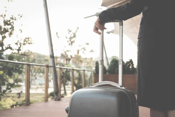 businesswoman pulling luggage outdoors. woman carrying baggage f