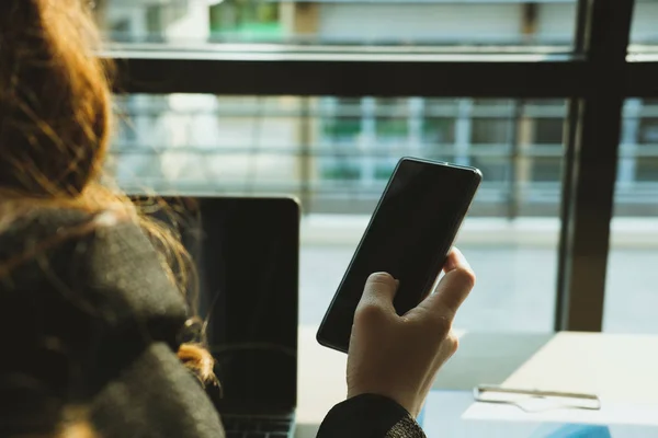 Деловая женщина, держащая в руках смс-ку с мобильного в офисе. yo — стоковое фото