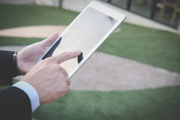 Businessman in suit holding touchpad while standing outside buil — Stock Photo, Image