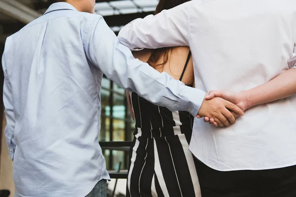 Гомосексуальный мужчина обнимает женщину, держа за руку тайного любовника . — стоковое фото