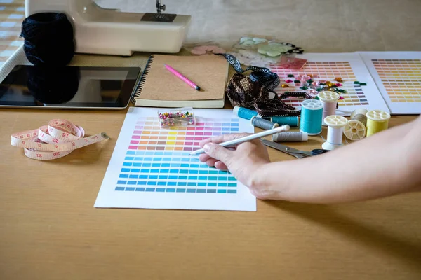 Hand of fashion designer working in studio with equipment on des — Stock Photo, Image