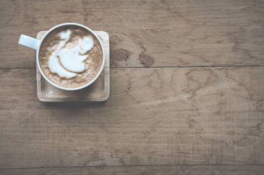 Ağaç sekmesinde beyaz fincan süt tepesi ile sıcak cappuccino kahve