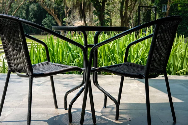 Чорний стіл на терасі будинку. плетене ротангове крісло на патіо не — стокове фото
