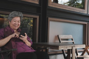 cep telefonu terasta tutan yaşlı kadın. yaşlı kadın metin