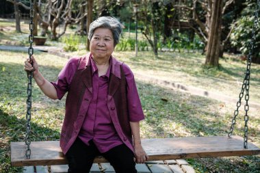 yaşlı kadın bahçede dinleniyor. yaşlı erkek salıncakta rahatlatıcı 