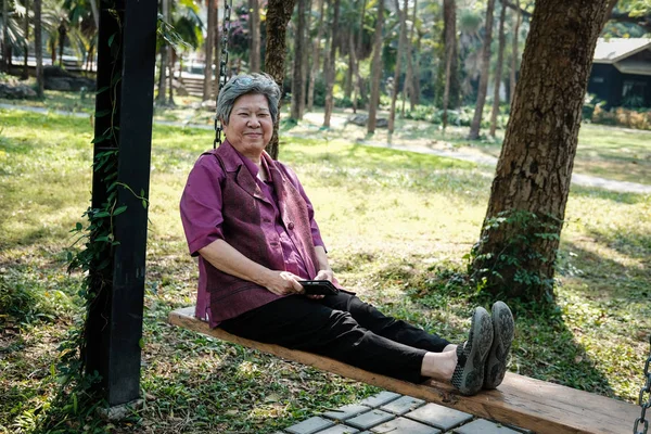 老妇人在花园里休息。老年女性摇摆放松 — 图库照片