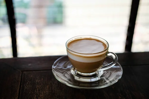 Hot espresso macchiato coffee with milk topping in glass cup on — Stock Photo, Image