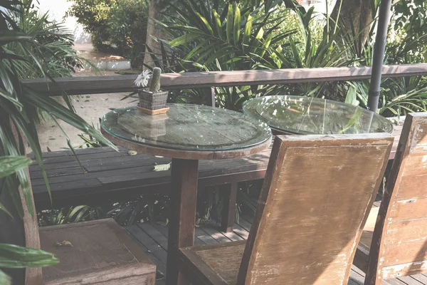 Круглий стіл на терасі будинку. дерев'яний стілець на патіо біля саду — стокове фото