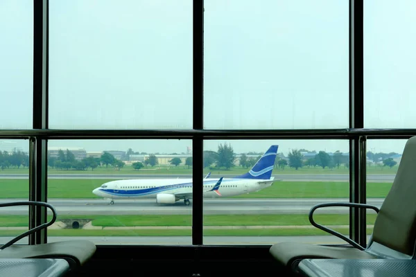 Krzesło w pobliżu okna w hali wylotów w terminalu lotniska — Zdjęcie stockowe