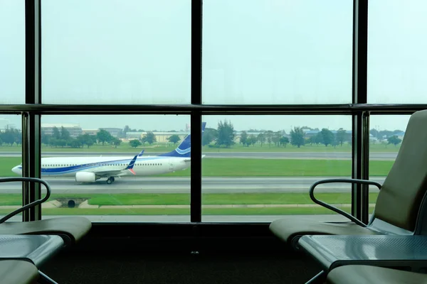 Havaalanı terminal kalkış salonda pencereye yakın sandalyede — Stok fotoğraf