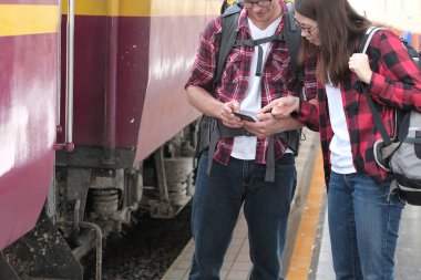 Adam ve kadın sırt çantası ile smartphone cep telefonu ile tren istasyonunda uygulamalarınızı