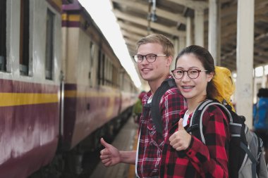 Erkek ve kadın için bekleyen sırt çantası ile tren istasyonunda tren. 