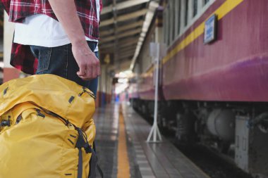 Erkek ve kadın için bekleyen sırt çantası ile tren istasyonunda tren.