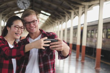 adam ve kadın akıllı telefon tren meydanının selfie fotoğraf çekmek için kullanın