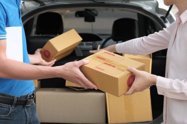 kadın teslim adamdan paketi alırsınız. başına erkek posta kurye