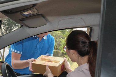 kadın teslim adamdan paketi alırsınız. başına erkek posta kurye