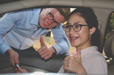 Satıcı müşteri için arabanın anahtarını ver. Satıcı kadın satın alma arabadan.