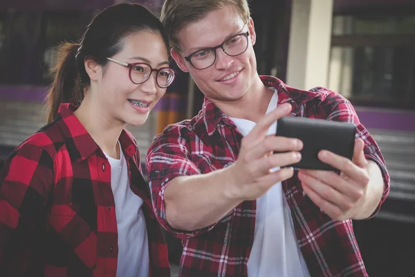 Adam ve kadın akıllı telefon tren meydanının selfie fotoğraf çekmek için kullanın — Stok fotoğraf